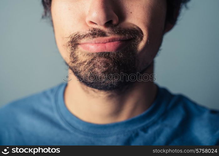 A young man with a beard is pulling silly faces