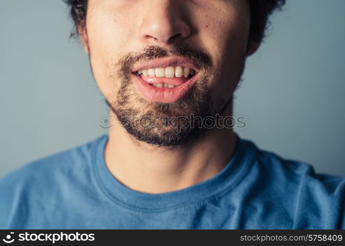 A young man with a beard is pulling silly faces