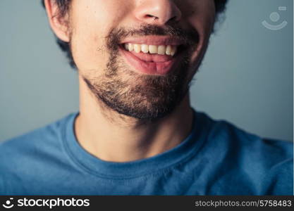 A young man with a beard is pulling silly faces