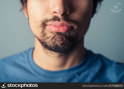 A young man with a beard is pulling silly faces