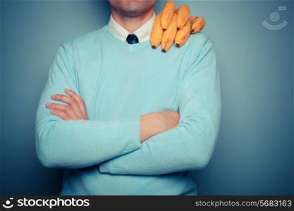 A young man with a bunch of bananas on his shoulder