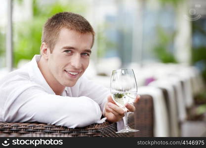 A young man with a glass in the cafe