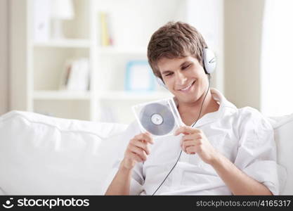 A young man with headphones and music CDs into the hands of