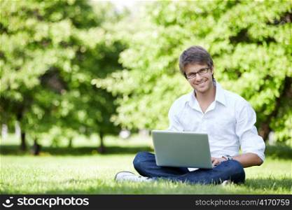 A young man with laptop outdoor