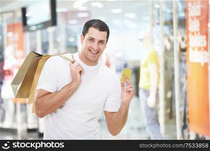 A young man with the shopping and credit card at the store