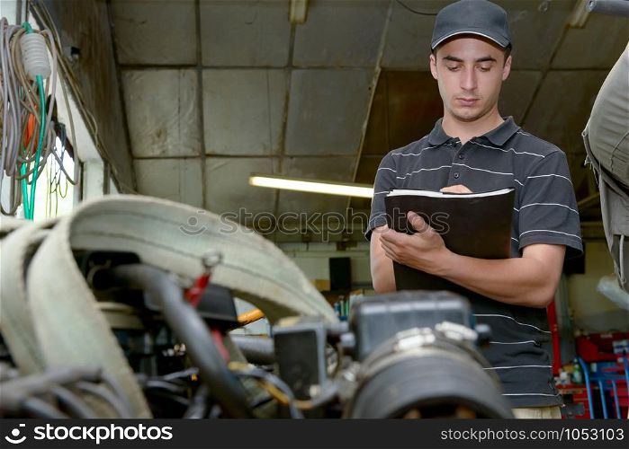 a young mechanic checking the engine