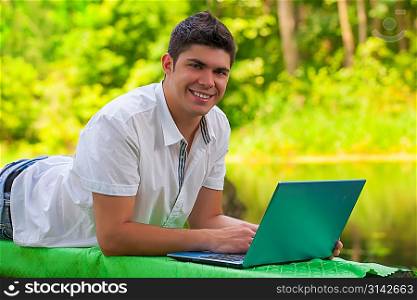 a young men lying with laptop