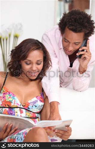a young metis woman and her boyfriend watching a brochure and calling someone