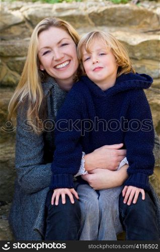 A young mother and her son together on some garden steps