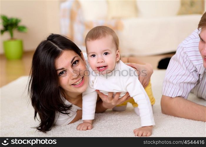 a young mother playing with her little baby at home