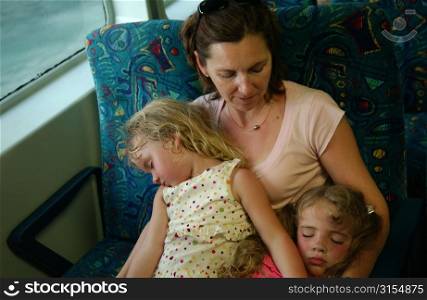 A young mother with her two daughters (10-12) sleeping in her arms, Moorea, Tahiti, French Polynesia, South Pacific