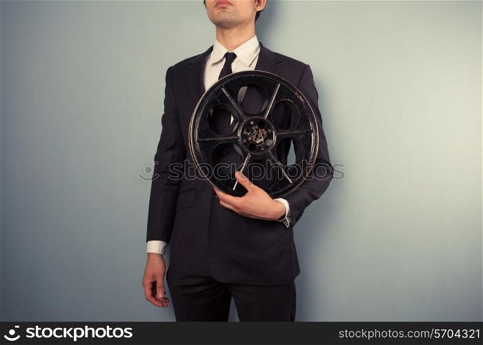 A young movie executive is holding an old film reel