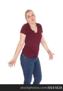 A young perplexed woman standing in jeans shrugging with hershoulder, she doesna??t know, isolated for white background