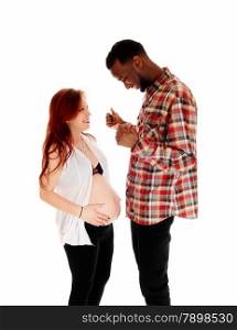 A young pregnant couple standing isolated for white background, theAfrican America man with his thump&rsquo;s up.