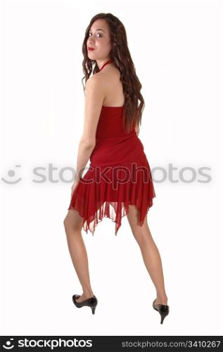 A young pretty woman in a red dress walkingin the studio, smiling, for white background.