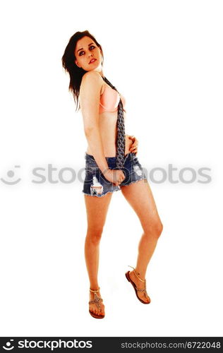 A young pretty woman standing for white background in shorts, an pinkbra and a blue tie.