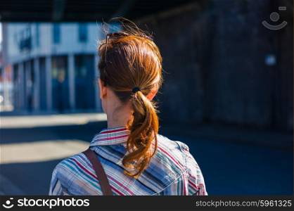 A young redhead woman is relaxing in the street on a sunny and warm spring day