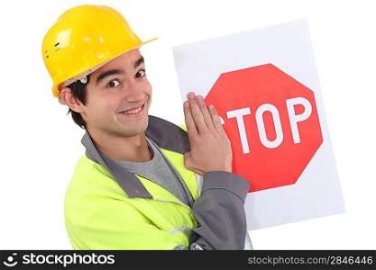 A young road worker holding a stop sign.