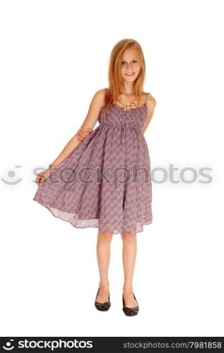 A young slim girl standing for white background in a burgundy dressand lifting up her dress.