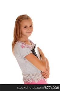 A young smiling blond girl a pink pants, holding her foldersclose to her chest, isolated for white background.