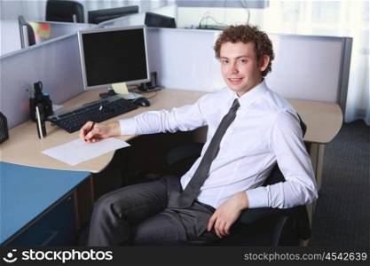 a young smiling businessman in formal wear in office