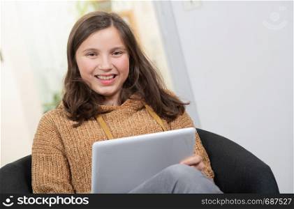 a young smiling teenager using a tablet computer