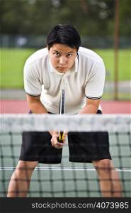 A young sporty asian male playing tennis