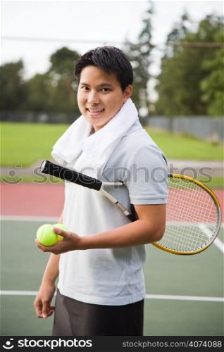 A young sporty asian male playing tennis