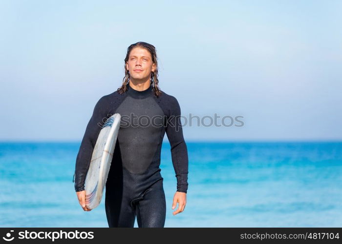 A young surfer with his board on the beach. Ocean is my life