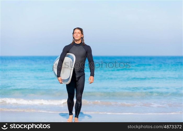 A young surfer with his board on the beach. Ocean is my life