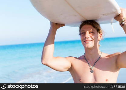 A young surfer with his board on the beach. Ready to hit waves