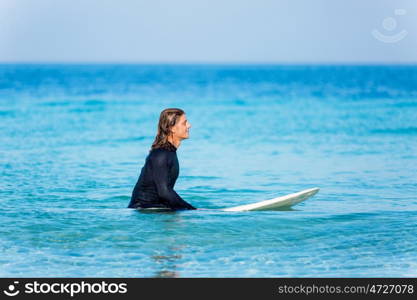 A young surfer with his board on the beach. Ready to hit waves