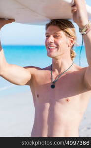 A young surfer with his board on the beach. Ready to hit waves