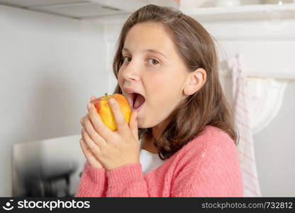 a young teenage girl eating an apple