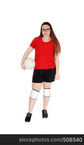 A young teenage girl in her uniform holding her volley ball in her hand, standing in the studio, isolated for white background