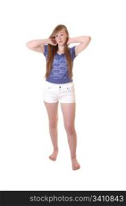 A young teenage girl in white shorts and blue blouse standing bare feetin the studio, playing with her long brunette hair for white background.