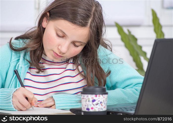 a young teenage girl is doing her homework