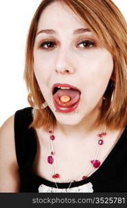 A young teenager girl with her mouth wife open and a pill on her tongue