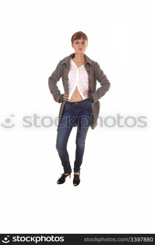 A young teenager in a brown winter coat, jeans and mittens walkingin the studio for white background.