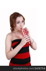 A young teenager in a red and black striped dress drinking juice froma pink glass, in a portrait shot for white background.
