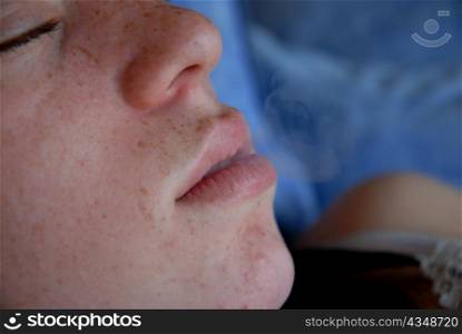 a young teenager making a smoke with her mouth