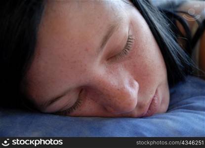 a young teenager sleeping in a blue bed