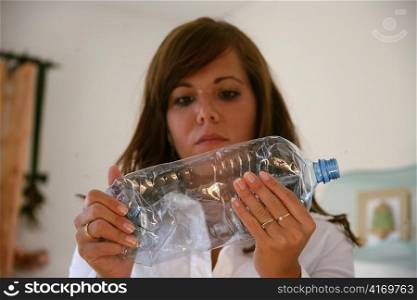 a young woman at the disposal of a plastic bottle
