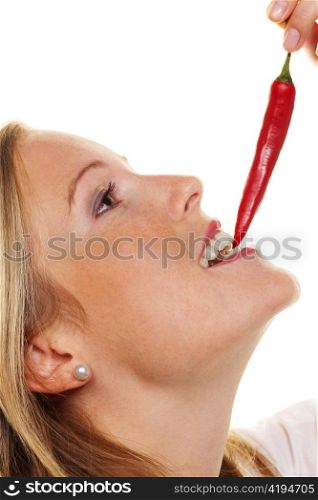 a young woman biting into a chili pepper. against a white background
