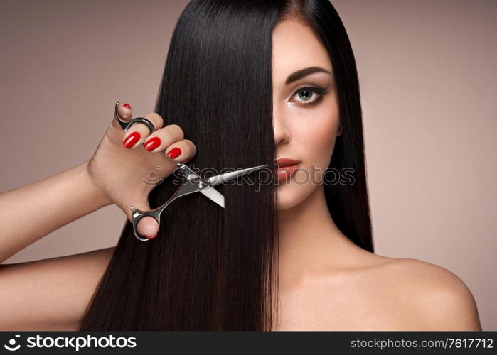 A young woman cutting her hair. Brunette model. Hair salon, hairstylist. Care and beauty hair products. Perfect make-up