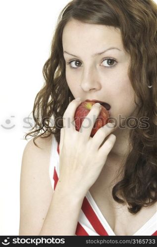 A young woman eats a red apple