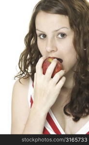 A young woman eats a red apple