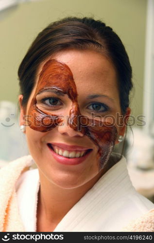 a young woman gets a chocolate mask in the beauty salon.