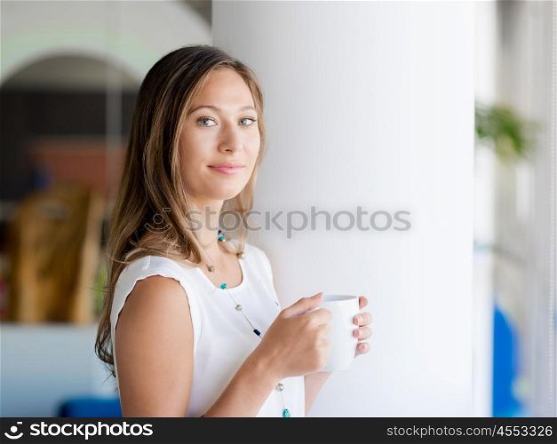 A young woman having coffee in office