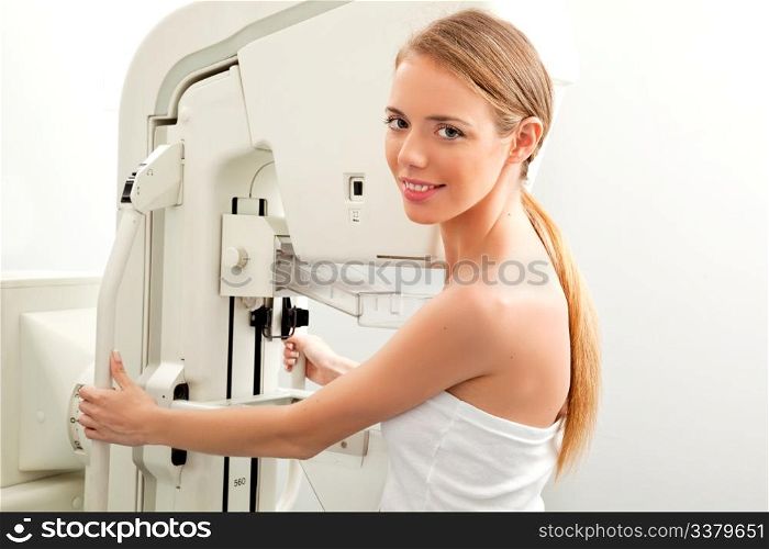 A young woman having taking a mammogram, looking at the camera